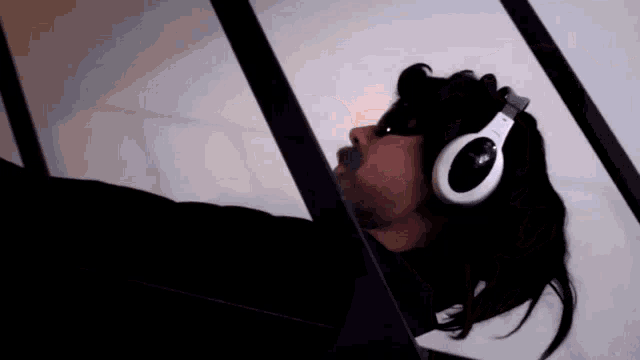 a man wearing headphones is laying down and looking up