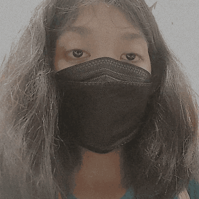 a woman wearing a black face mask with long hair