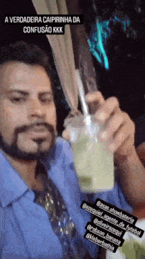 a man with a beard is holding up a cup of liquid with a straw