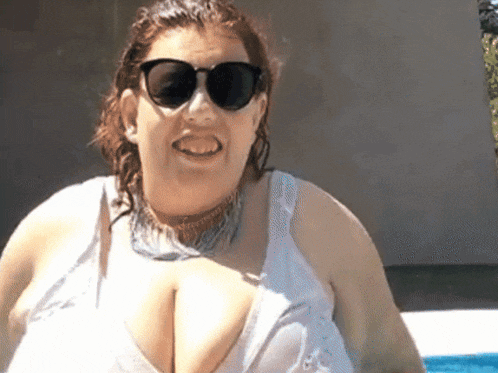 a woman wearing sunglasses and a white tank top smiles