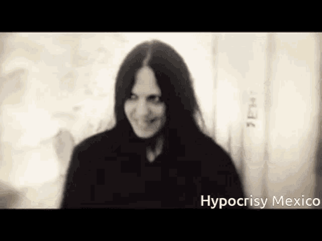a woman with long hair is smiling in a black and white photo with hypocrisy mexico written on the bottom .