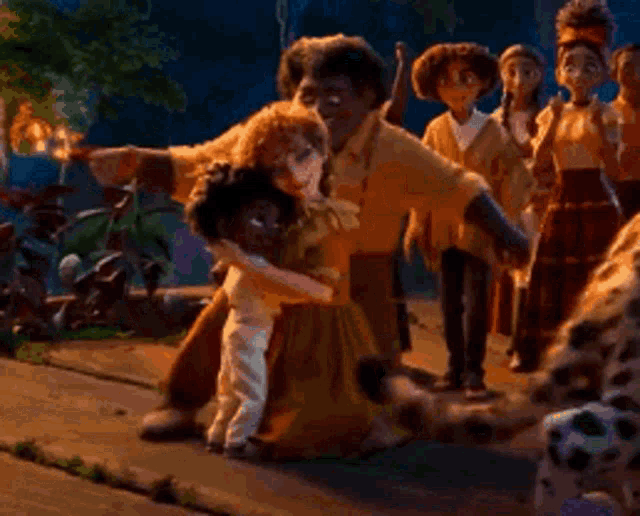 a group of people are standing around a woman kneeling down and hugging her .