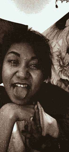 a woman with her tongue out and a nose ring
