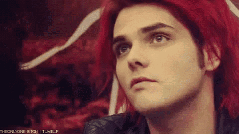 a close up of a person 's face with red hair and a black jacket .