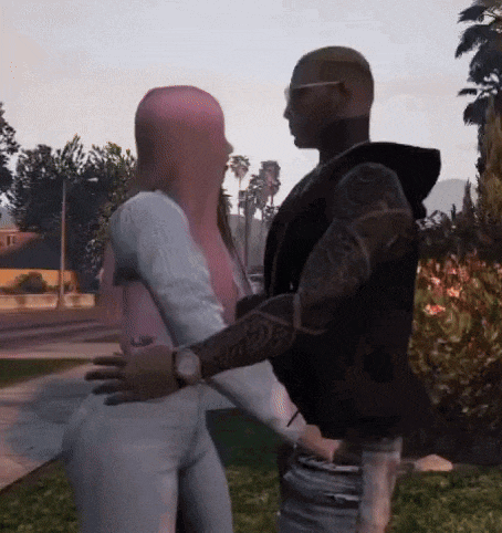 a man and a woman are hugging each other in a park . the woman has pink hair .