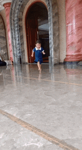 a little girl in a blue dress is running in front of a building