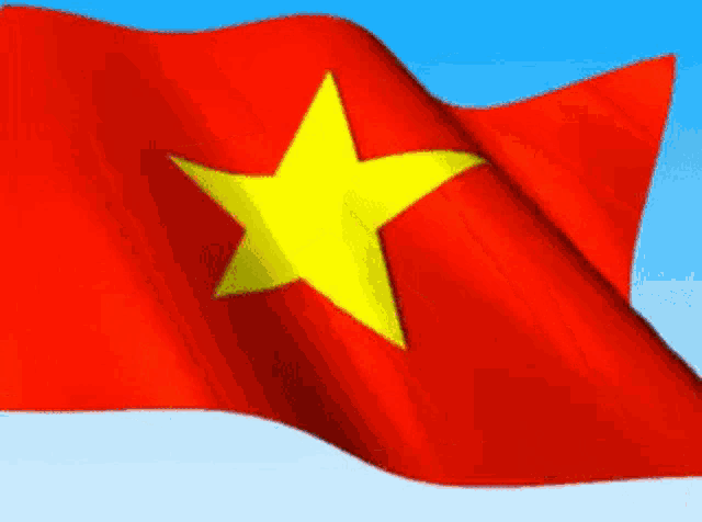 a red flag with a yellow star on it is flying in the wind