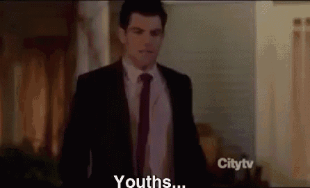a man in a suit and tie is standing in a living room and talking to someone .