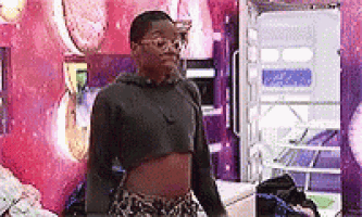 a woman is standing in a room wearing a crop top and leopard print shorts .