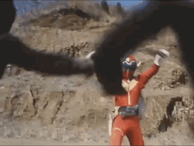 a man in a red superhero costume is being attacked by a black monster .