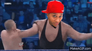 a man in a red hat is standing in a wrestling ring with two other men