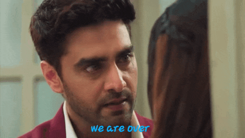 a man and a woman are looking at each other and the words we are over are on the bottom of the screen .