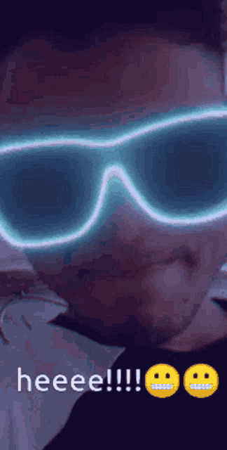 a man wearing glow in the dark sunglasses says heee !!!