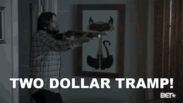 a man in a plaid shirt is holding a gun and says " two dollar tramp "