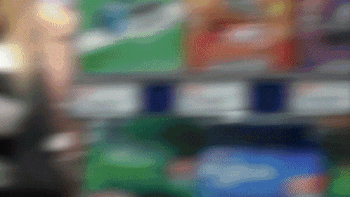 a blurred image of a store shelf with a few items on it including coca cola