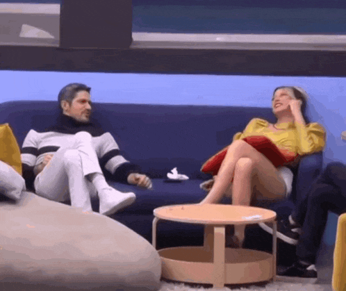 a man and a woman are sitting on a blue couch