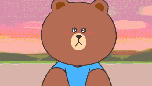 a brown teddy bear wearing a blue shirt is looking at the camera