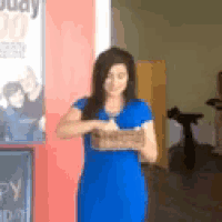a woman in a blue dress is holding something in her hands