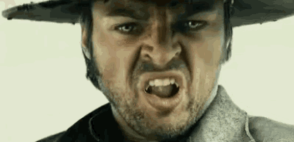 a man with a beard and hat is making a funny face .