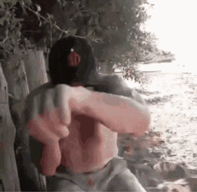 a man wearing a hat with the letter r on it is hugging another man .