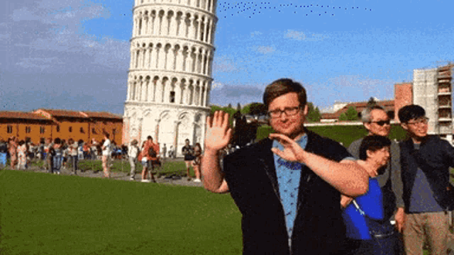 a man stands in front of a very tall tower