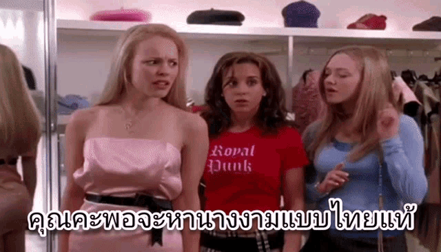 a woman wearing a red shirt that says royal punk is standing next to two other women .