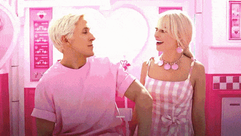 a man and a woman are standing next to each other in a pink room