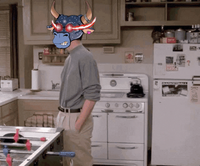 a man standing in a kitchen wearing a bull mask