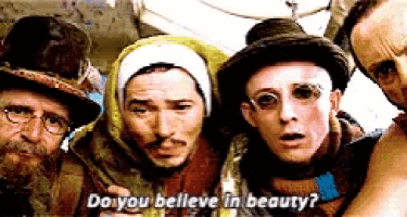 a group of men are standing next to each other and one of them is asking do you believe in beauty