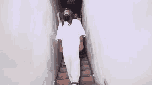 a man in a white shirt is standing in a room with smoke coming out of it .