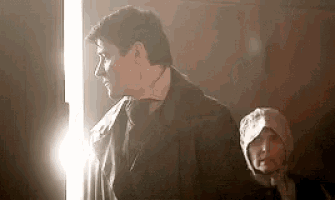 a man and a woman are standing in a dark room .