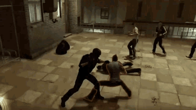 a group of men are playing a video game and one of them is wearing a black helmet