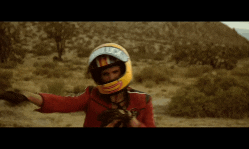 a woman wearing a yellow helmet with the letter t on it