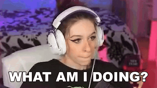 a woman wearing headphones is sitting in front of a computer and says `` what am i doing ? ''