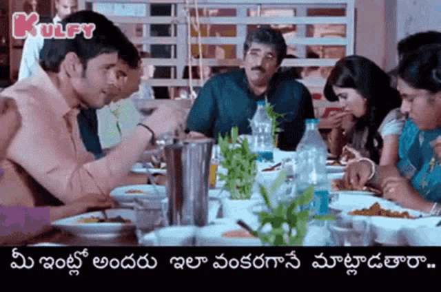 a group of people are sitting at a table eating food in a restaurant with the words kulfy in the corner