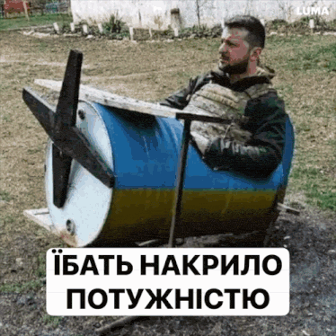a man is sitting in a blue and yellow barrel with a propeller attached to it