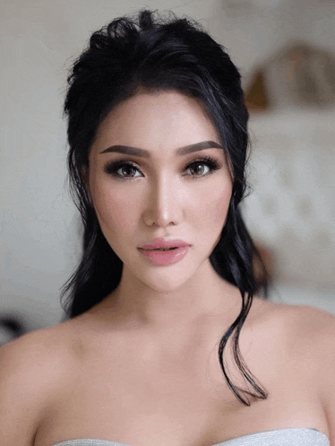 a woman with black hair is wearing a white top