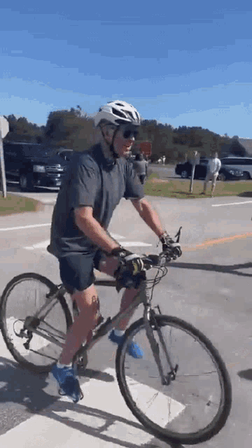 a man wearing a helmet is riding a bike on the street