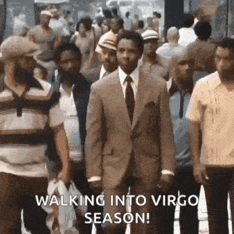 a man in a suit and tie is walking through a crowd of people on a city street .