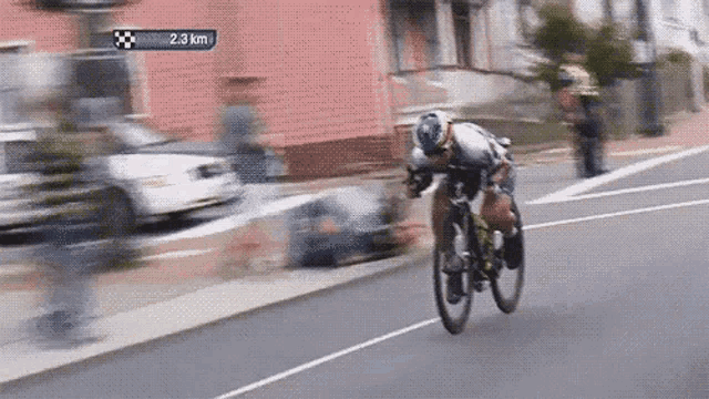 a person is riding a bike down a street with a sign that says 2.3 km in the background