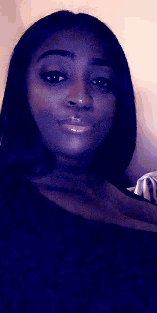 a woman in a black shirt looks at the camera