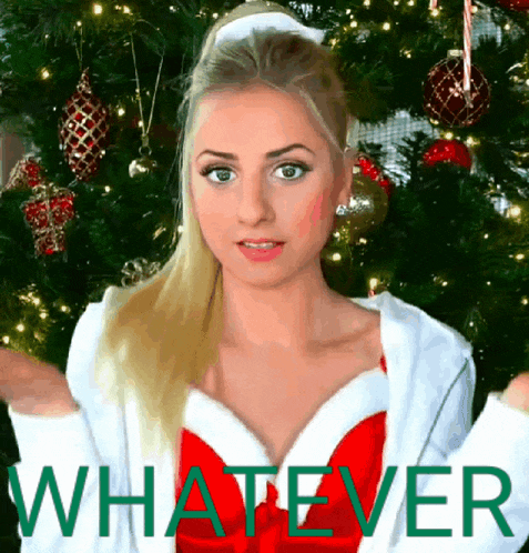 a woman standing in front of a christmas tree with the word whatever in green