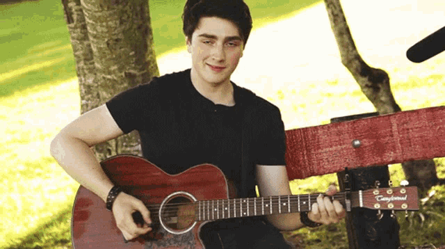 a young man is playing a guitar that says campbell