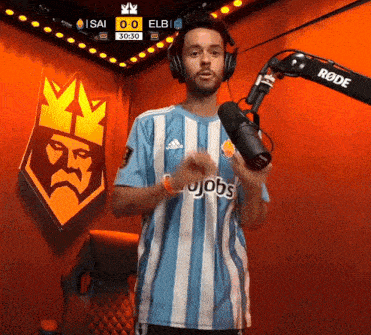 a man wearing headphones stands in front of a microphone and a scoreboard that says isai 0-0 elb