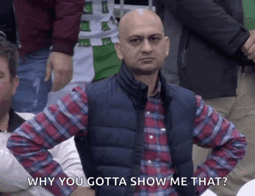 a man in a plaid shirt and vest says why you gotta show me that