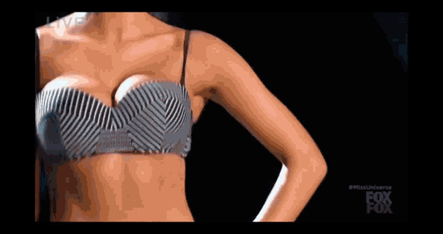 a woman in a striped bra is standing in front of a black background with the word live on it