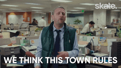 a man in an office with the words we think this town rules behind him