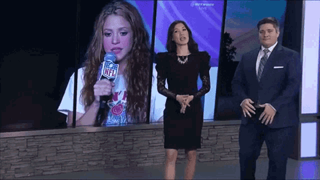 a man and a woman standing in front of a screen that says nfl on it