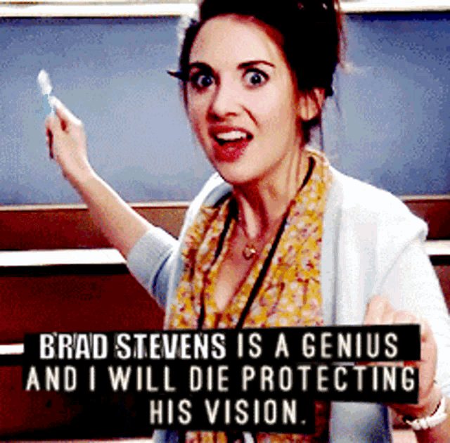 a woman with a sign that says brad stevens is a genius and i will die protecting his vision