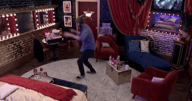 a man is dancing in a room with red chairs